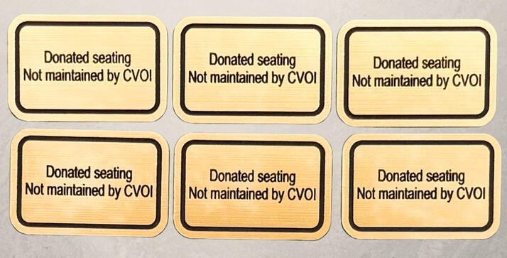 A bulk order of six custom laser-engraved gold brushed-metal effect plaques with black borders. The text reads 'Donated seating Not maintained by CVOI—perfect for memorial benches, park donations, and commercial furniture identification.